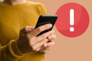 Persona con cellulare, simbolo attenzione